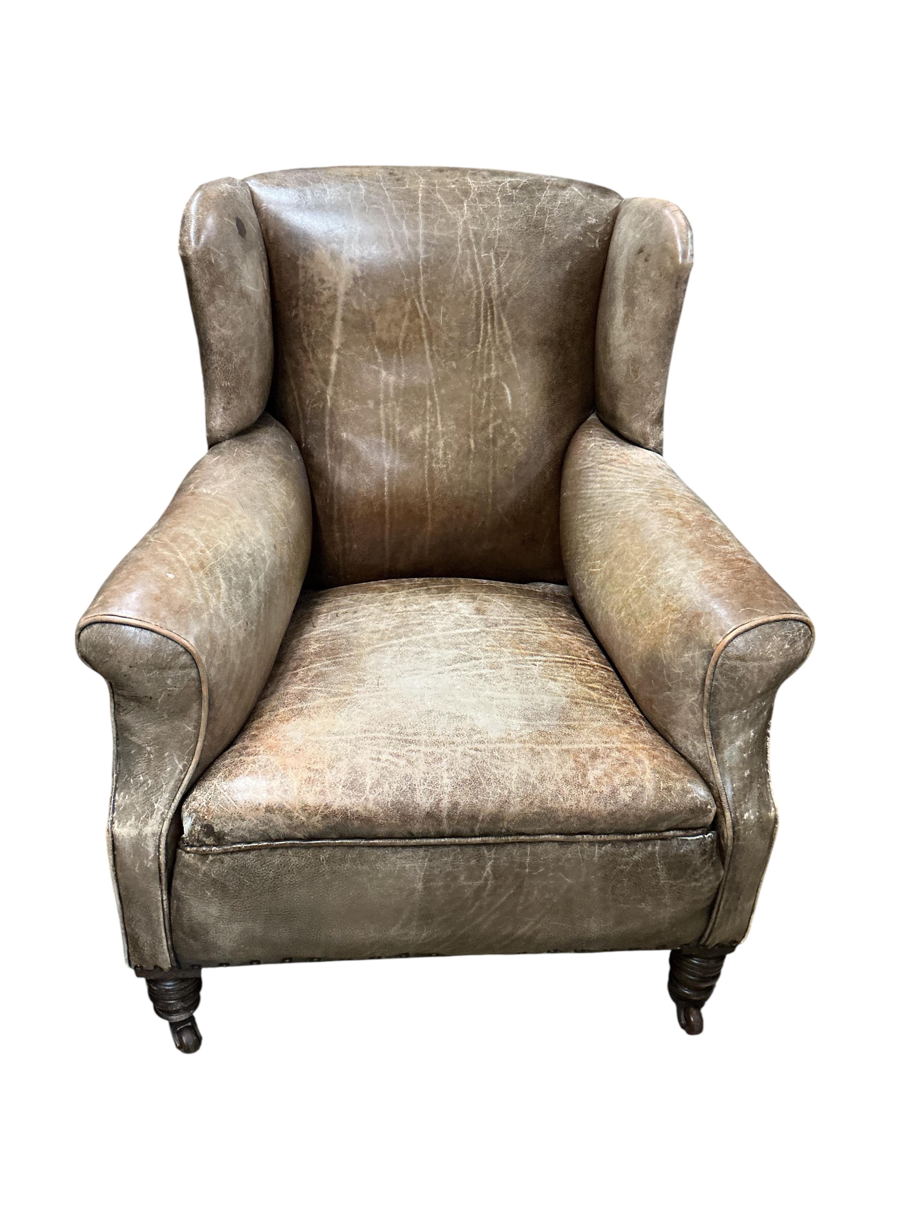 A pair of late Victorian brown leather wing armchairs, width 78cm, depth 76cm, height 89cm